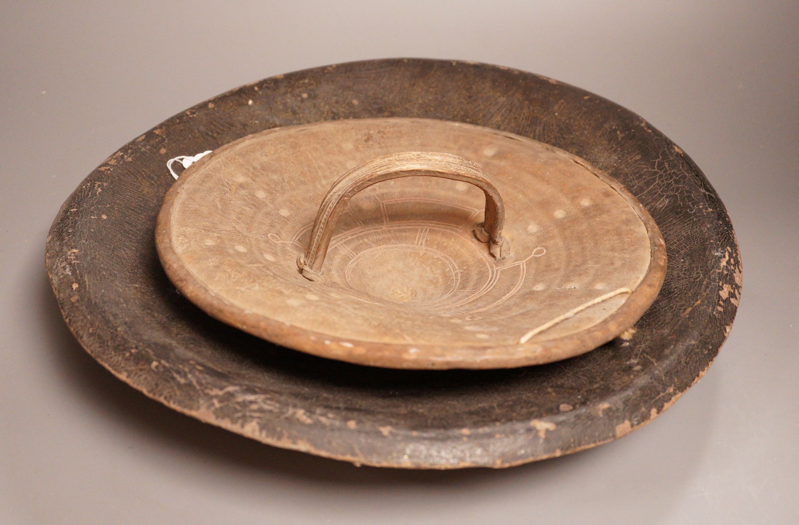A 19th century Indo-Persian animal hide dahl shield, 41cm diameter, and an African rhino hide shield